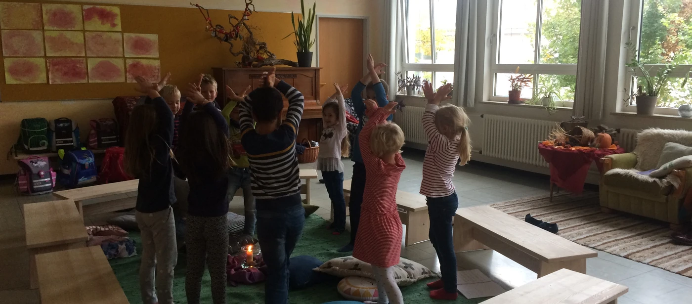 Kinder bewegen sich zwischen Bänken im Klassenzimmer
