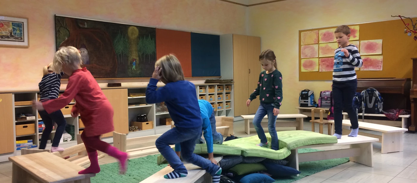 Kinder balancieren über Bänke und Kissen im Klassenzimmer